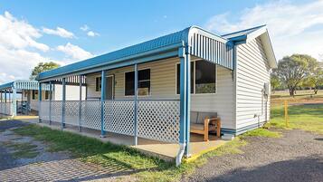 A single-story mobile home with a blue roof and a covered porch area.