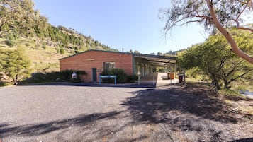 Un edificio de ladrillo con un porche cubierto, un letrero que dice “COMMUNITY HALL” y un camino de grava.