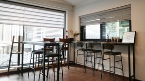 Eine moderne Küche mit Barbereich, großen Fenstern und Blick auf die Stadt.