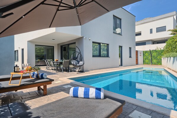 Piscina all'aperto, una piscina riscaldata, lettini