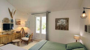A bedroom with a bed, a desk, a chair, a television, and artwork on the walls. - Gîte "U Caseddu (Ortiporio)