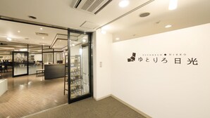 An office space with a reception area, glass partitions, and a wall with signage. - YUTORELO NIKKO - Hostel (Nikko)