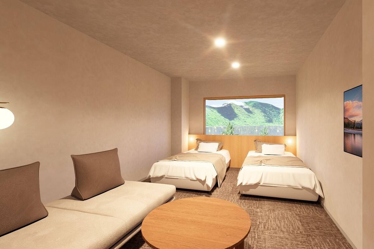A hotel room with two beds, a sofa, a round coffee table, and a large window with a mountain view.