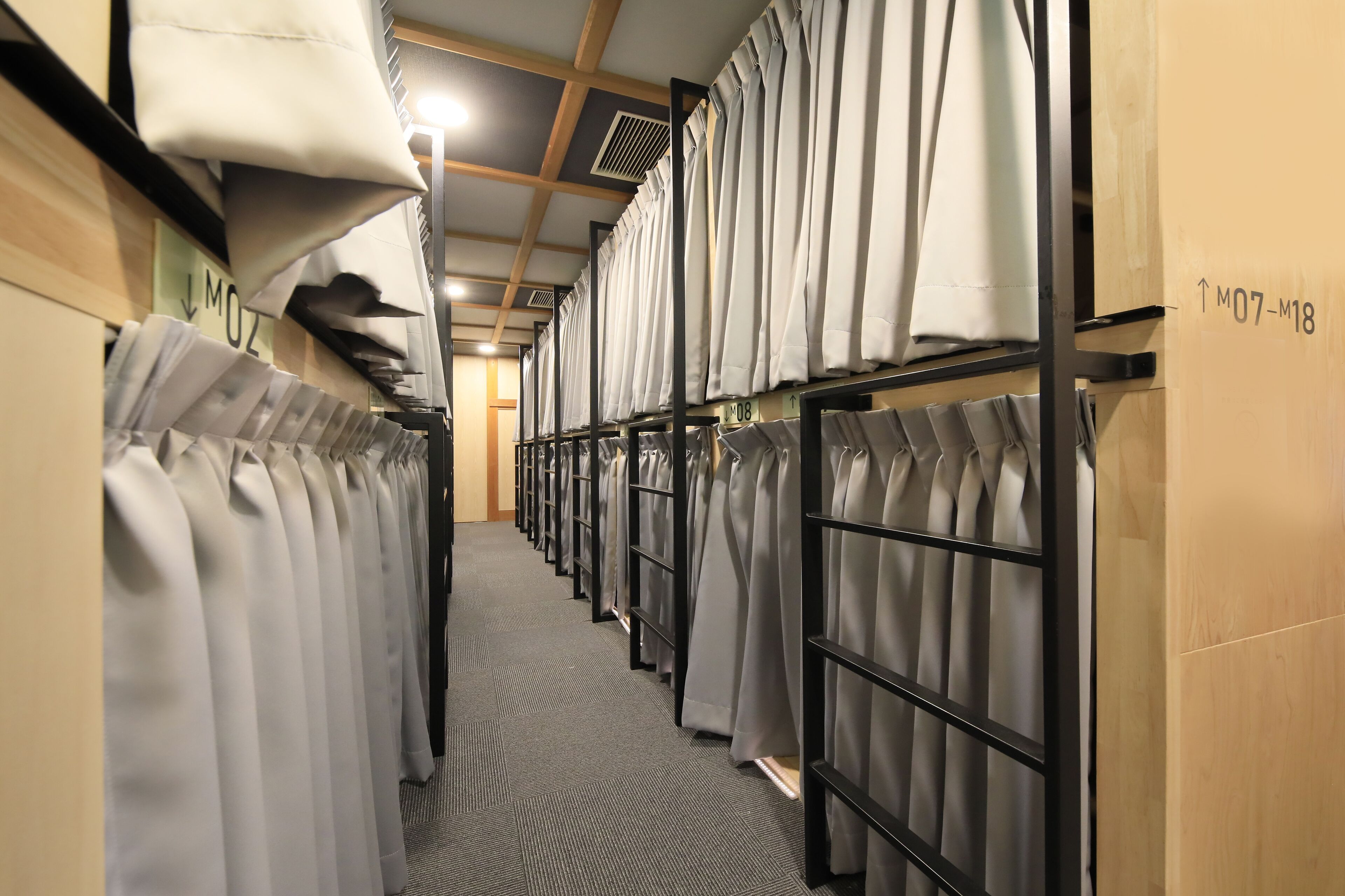 Un pasillo de hotel con hileras de cortinas ordenadas y suelo alfombrado.