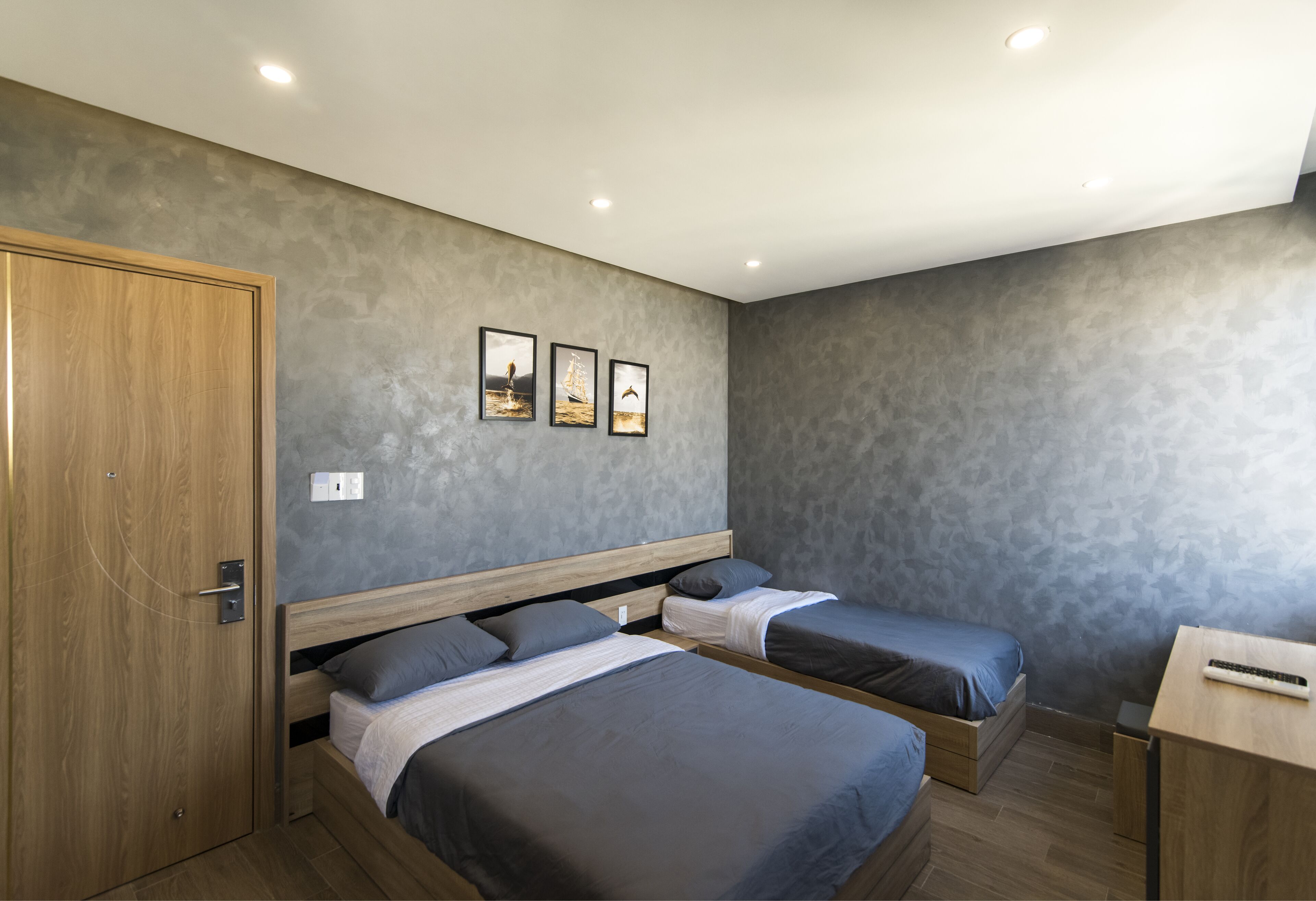 Een slaapkamer met twee bedden, een houten garderobe en een bureau.