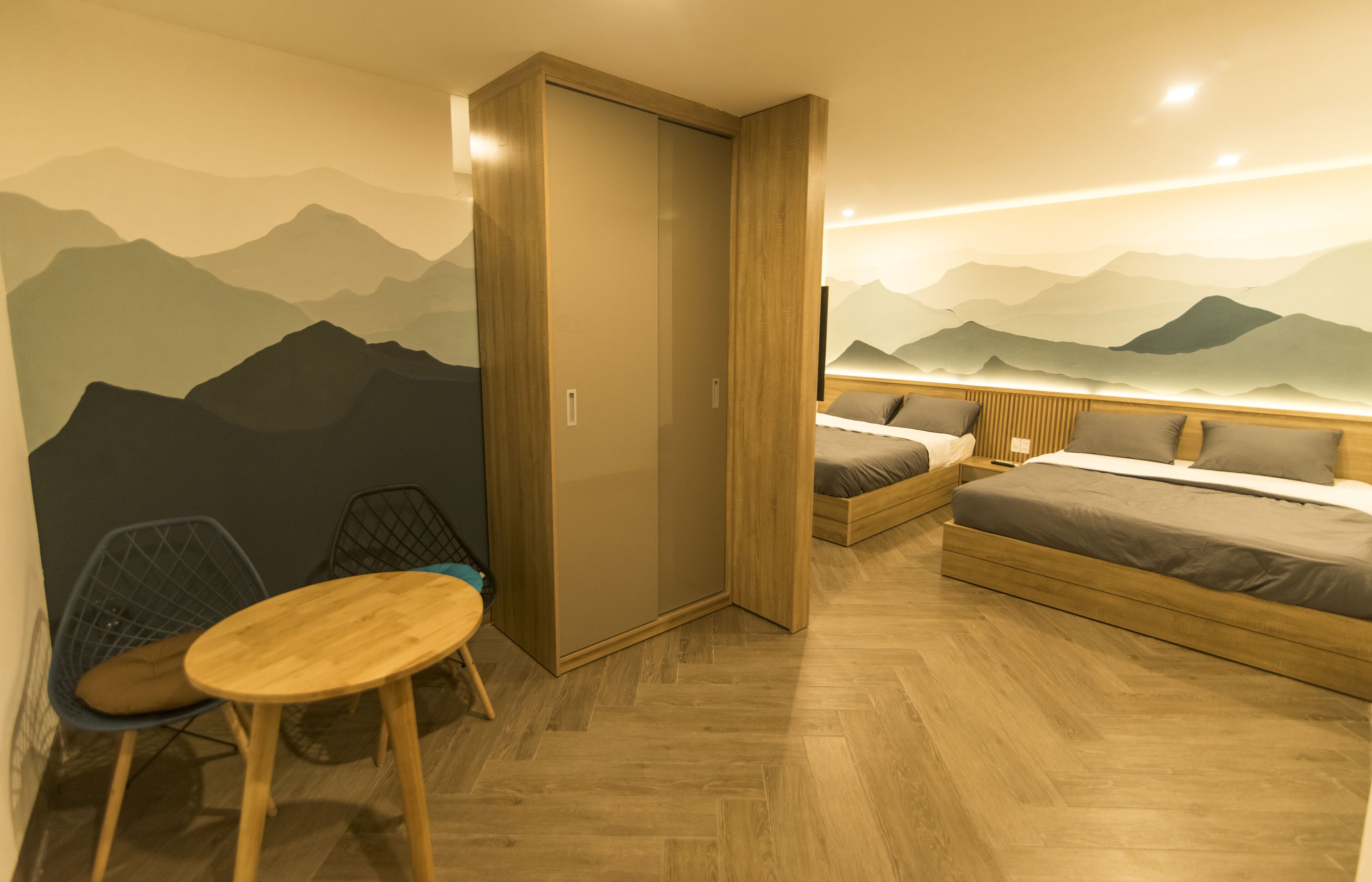 Un dormitorio pequeño con cama, una mesita y un armario.