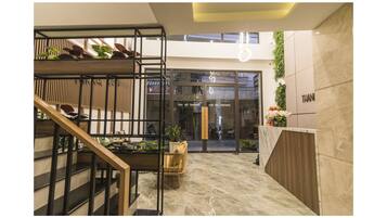 A modern interior with a wooden staircase, a seating area, and a reception desk.