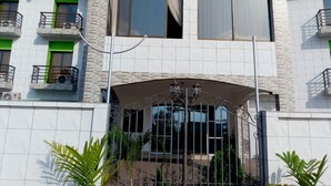 A multi-story building with a modern architectural style, featuring balconies with railings and a central entrance with a decorative archway. - Hotel Samaki Plage (Kribi)