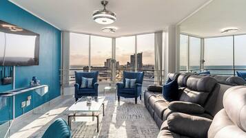 Un salón moderno con vistas a la ciudad, amplias ventanas y muebles contemporáneos.