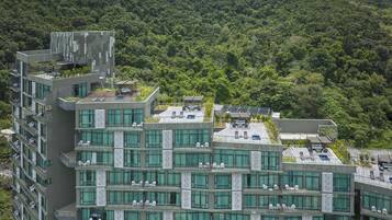 Un hôtel moderne à plusieurs étages, doté de balcons, de grandes fenêtres et de panneaux solaires.