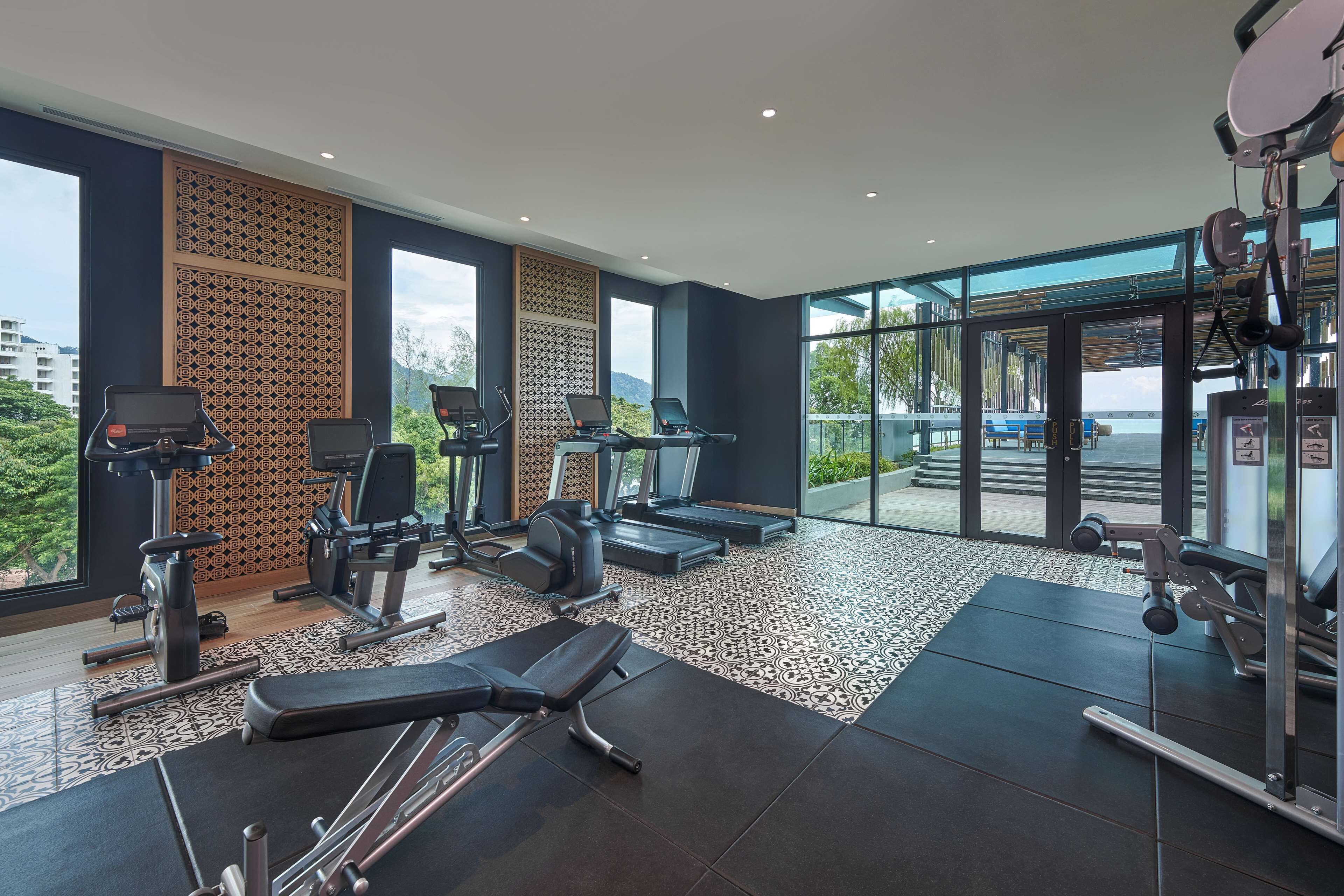 Ein modernes Fitnessstudio mit Laufbändern, Crosstrainern und Gewichtsmaschinen.
