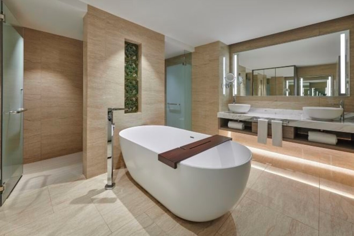 Une salle de bain moderne avec une baignoire sur pieds, un grand miroir et un meuble-lavabo doté de deux vasques.