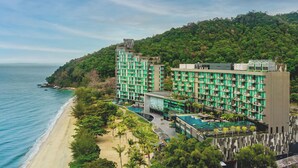 A hotel with multiple floors, a pool, and a beach view.