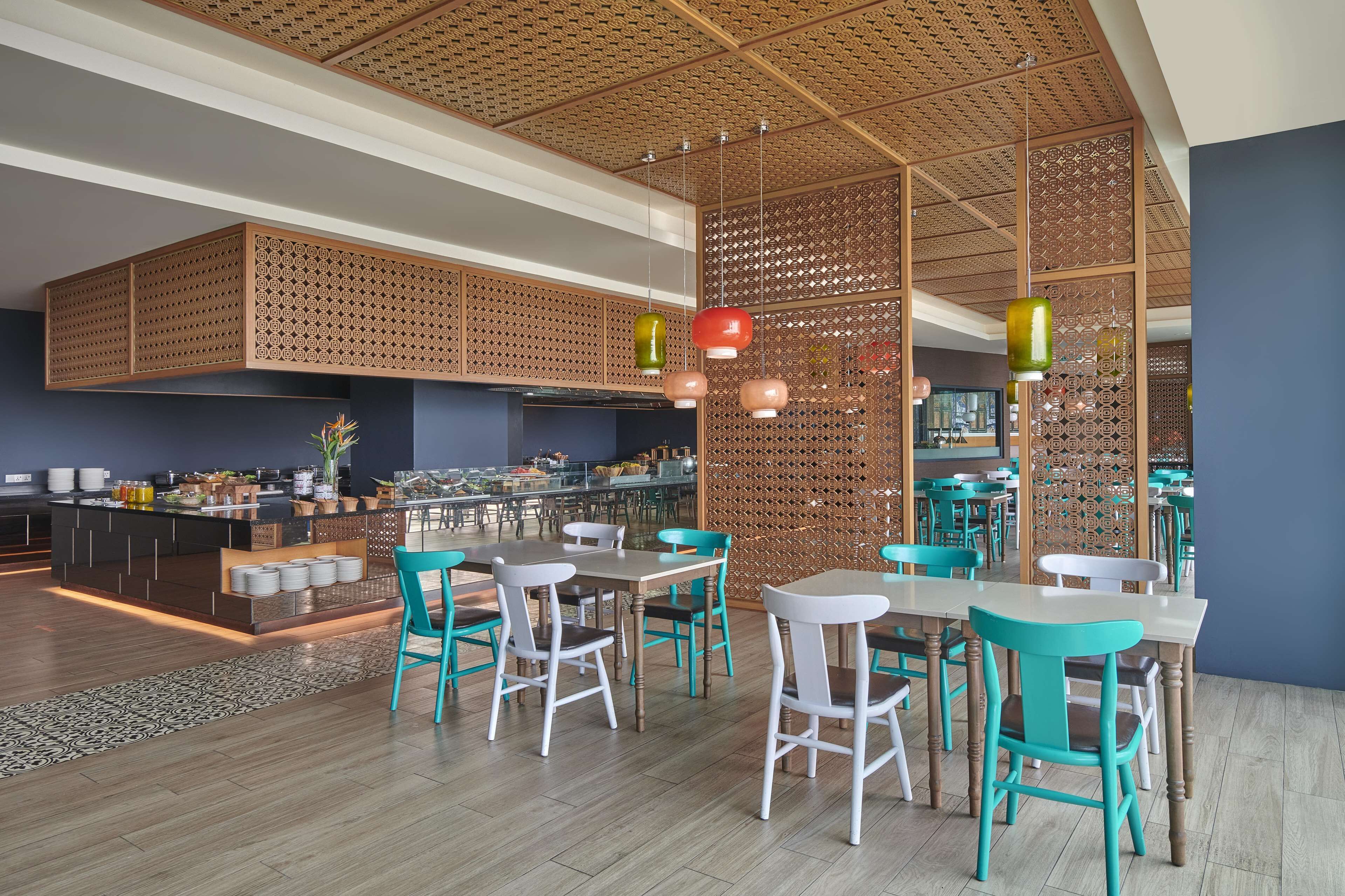 Un intérieur de restaurant moderne avec des cloisons en panneaux de bois, des chaises de couleur turquoise et un bar central.