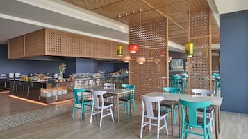 Un intérieur de restaurant moderne avec des cloisons en panneaux de bois, des chaises de couleur turquoise et un bar central.