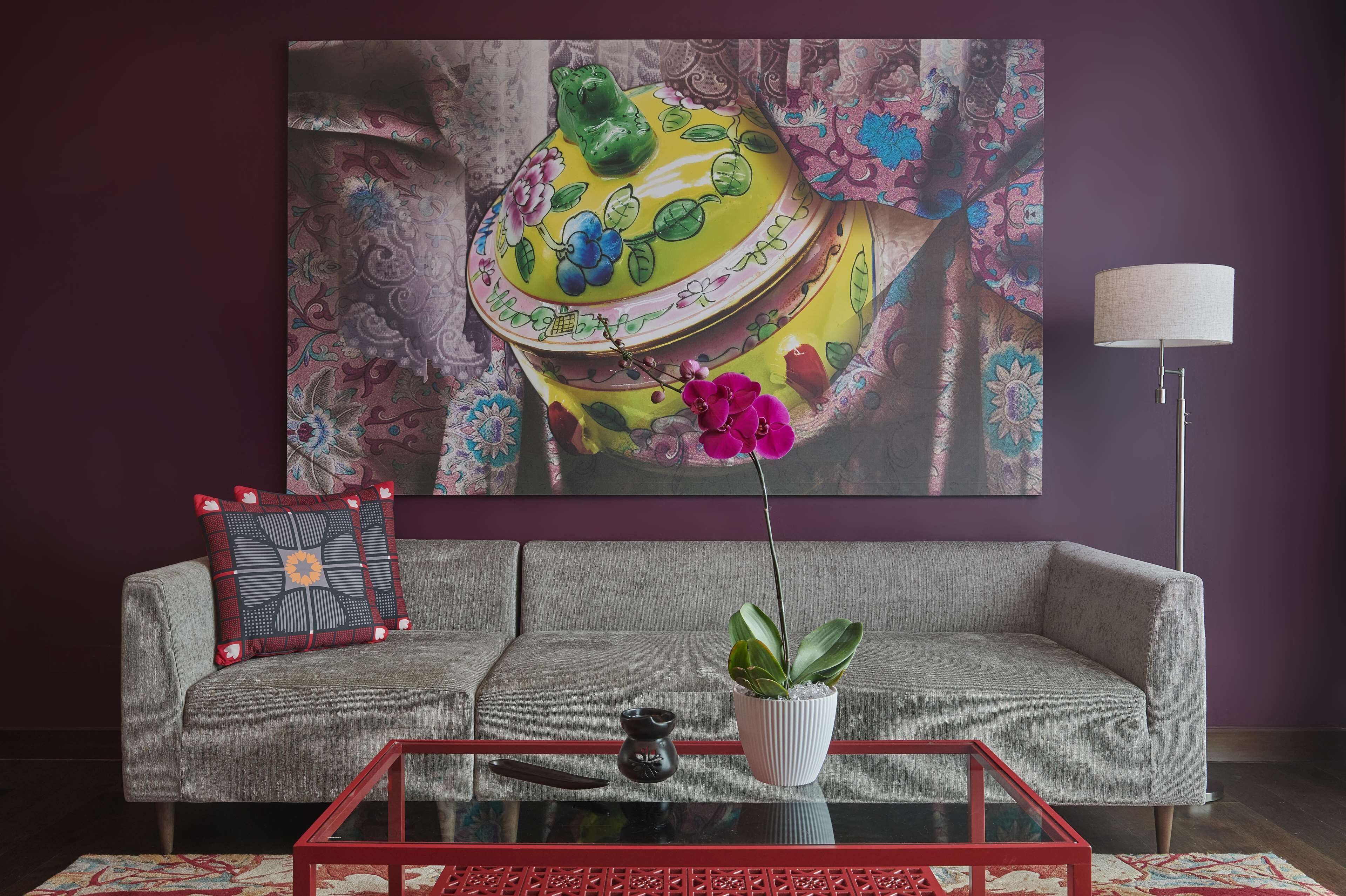 Un salon avec un canapé, une table basse, une lampe et un tableau au mur.