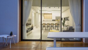 A modern living room with a sliding glass door leading to a dining area. - Mr. Louis - By TLV2GO (Tel Aviv)