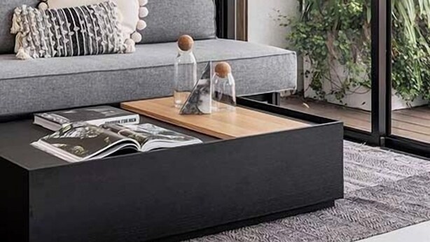 A modern living room with a grey sofa, a black coffee table, and a large window with a view of greenery. - Mr. Louis - By TLV2GO (Tel Aviv)