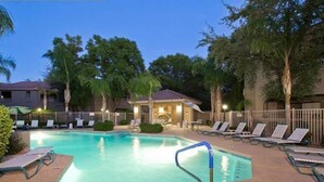 A swimming pool with lounge chairs and a small building in the background. - Arizona Hideaway (Scottsdale)