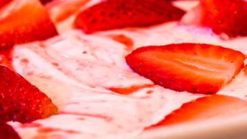 A dessert with strawberries and a creamy topping.