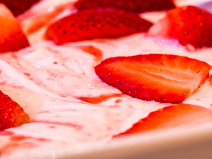 A dessert with strawberries and a creamy topping.