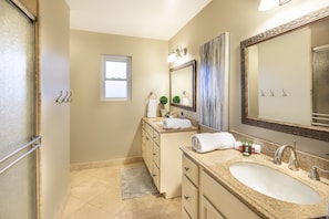 A bathroom with a large sink, vanity, and a mirror. There is a window and a towel rack. - Scottsdale Getaway (Scottsdale)