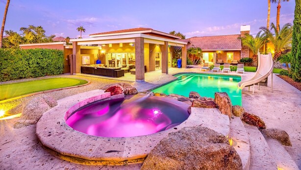 Ein Resort mit Pool, Whirlpool und Sitzgelegenheiten im Freien.