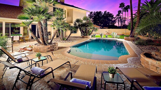 A poolside area with lounge chairs, a small pool, and palm trees. - Tatum Place (Phoenix)