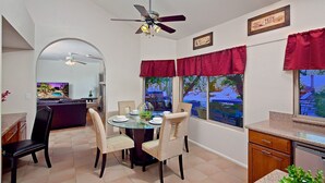 A dining area with a round table, chairs, and a ceiling fan. - Tatum Place (Phoenix)