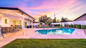 A backyard with a swimming pool, outdoor seating, and a covered patio area. - Old Town Retreat (Scottsdale)