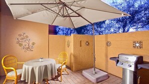 An outdoor patio with a round table, two wicker chairs, a barbecue grill, and a large umbrella. - Tempe Escape · Prime Location, Sparkling Pool, Bbq, Tennis Court (Tempe)