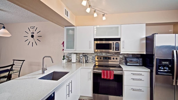 A modern kitchen with white cabinets, stainless steel appliances, a built-in oven, a microwave, and a dishwasher. - Tempe Escape · Prime Location, Sparkling Pool, Bbq, Tennis Court (Tempe)