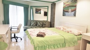 Een hotelkamer met een bed, een bureau, een stoel en een schilderij aan de muur.