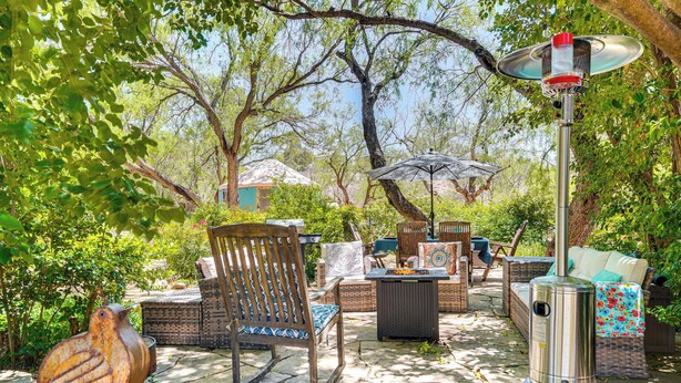 An outdoor patio with stone flooring, wicker furniture, and a bird sculpture. - Vibrant 'Casa Paloma' w/ Patio - Near Vineyards! (Patagonia)