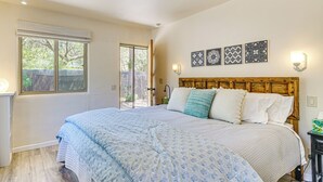A bedroom with a large bed, a wooden headboard, and a window with blinds. - Vibrant 'Casa Paloma' w/ Patio - Near Vineyards! (Patagonia)