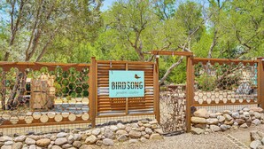 A wooden gate with a sign reading "Birdsong Garden Casas" surrounded by rocks and trees. - Vibrant 'Casa Paloma' w/ Patio - Near Vineyards! (Patagonia)