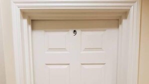 A white door with a round doorknob and a small circular lock plate.