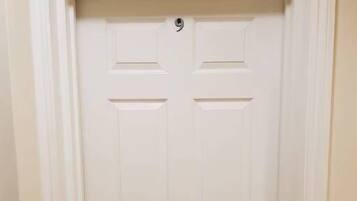 A white door with a round doorknob and a small circular lock plate.