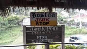 A signboard for 'Boston Jerk Stop' listing jerk pork, chicken, fish, and lobster.