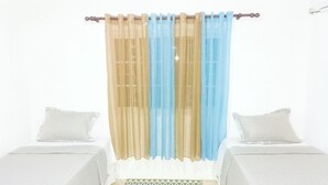 A room with two beds, a patterned rug, and sheer curtains. - Chantal House Sleeps 8 With Garden (Windsor Castle)