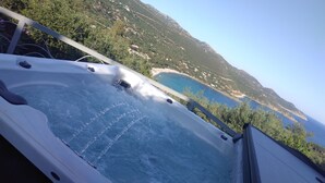 A hot tub with a view of a coastal landscape and a mountainous area. - Luxury Beach Escape, Sea View Hottub,cinema Lounge (Maracalagonis)