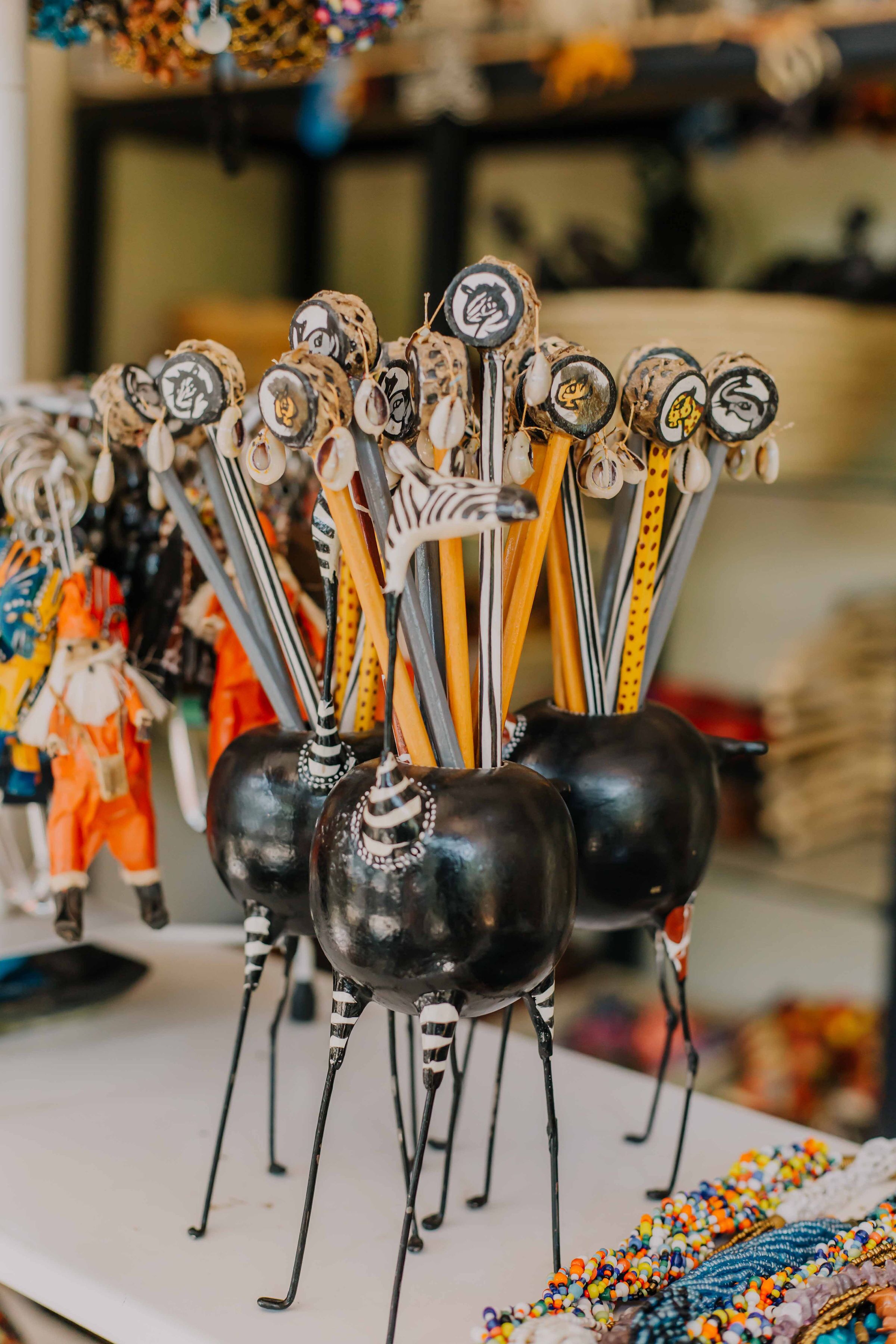 Una exhibición de objetos decorativos, entre ellos figuritas y cuentas, dispuestas sobre una mesa.