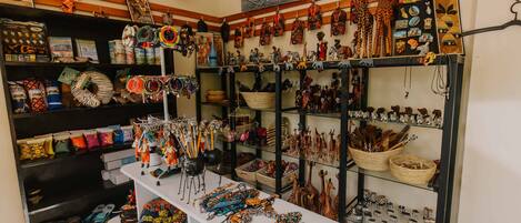 Une pièce où l’on trouve des étagères exposant divers articles, notamment des sacs, des chapeaux et des bijoux.