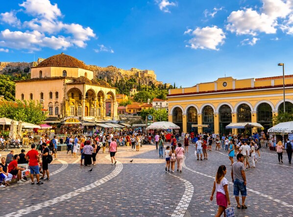A bustling square with historical buildings, a central fountain, and a crowd of people.