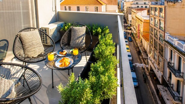 A rooftop terrace with wicker chairs, a table with food and drinks, and a view of the cityscape. - Ermou w Jacuzzi Acropolis View Monastiraki (Athina)