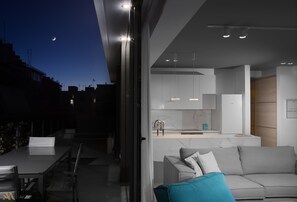 A modern interior with a dining area, a sofa, and a kitchen. - Elysium Boutique Apartments (Zografos)