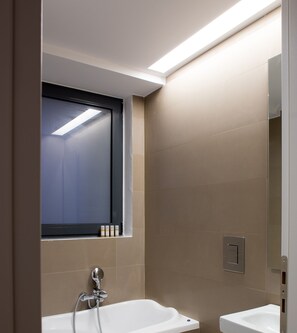 Un baño moderno con bañera, lavamanos y ventana.
