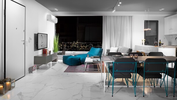 A modern living room with a sofa, dining table, and chairs. There is a kitchen area with cabinets and a sink. - Elysium Boutique Apartments (Zografos)
