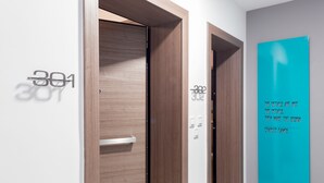 A modern hotel corridor with wooden doors labeled "301" and "302". - Elysium Boutique Apartments (Zografos)