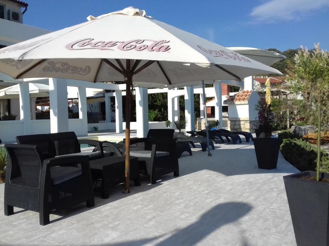 Un espace extérieur aménagé avec des parasols et des meubles en osier aux couleurs de Coca-Cola.